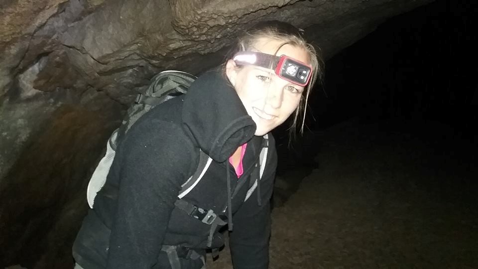 lindsey jacobs inside a cave with headlamp